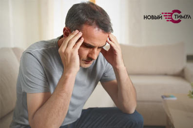 Мужчина сидит в болезненном состоянии